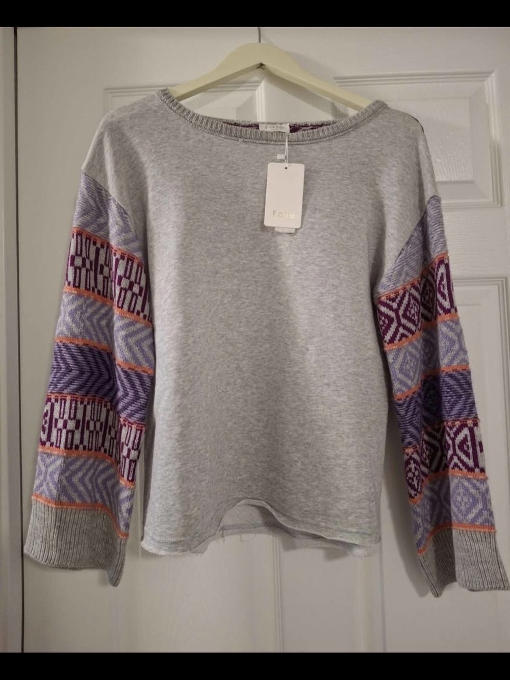 The light gray sweatshirt with detailed bell sleeves